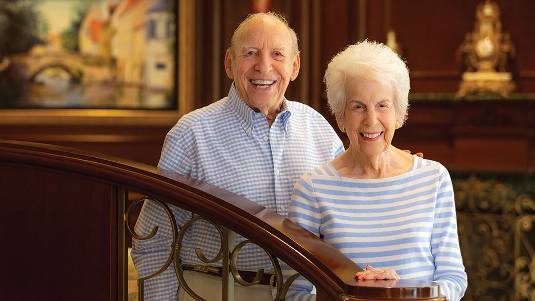 A couple standing in front of a staircase.