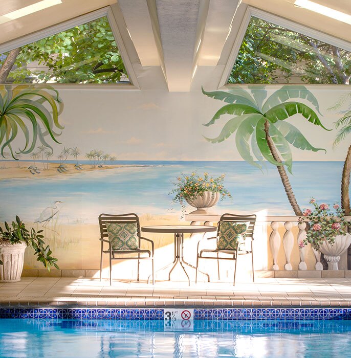Empty chairs sitting next to an indoor pool.