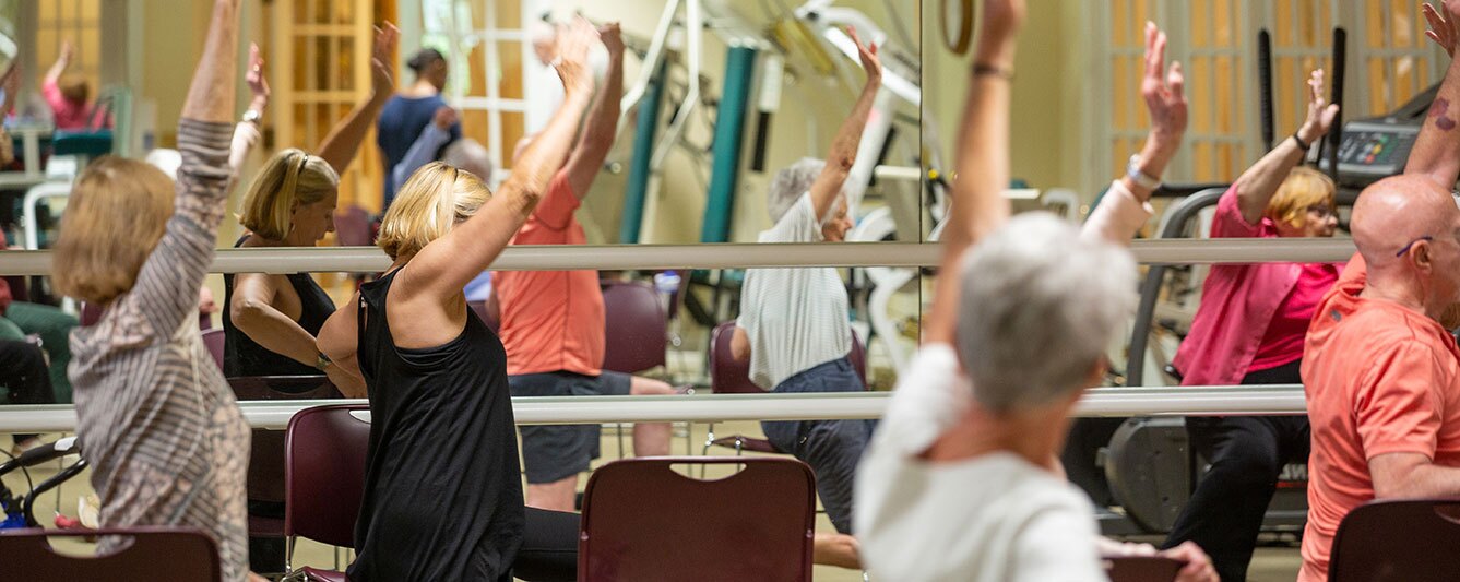 Residents sitting down in front of a large mirror.