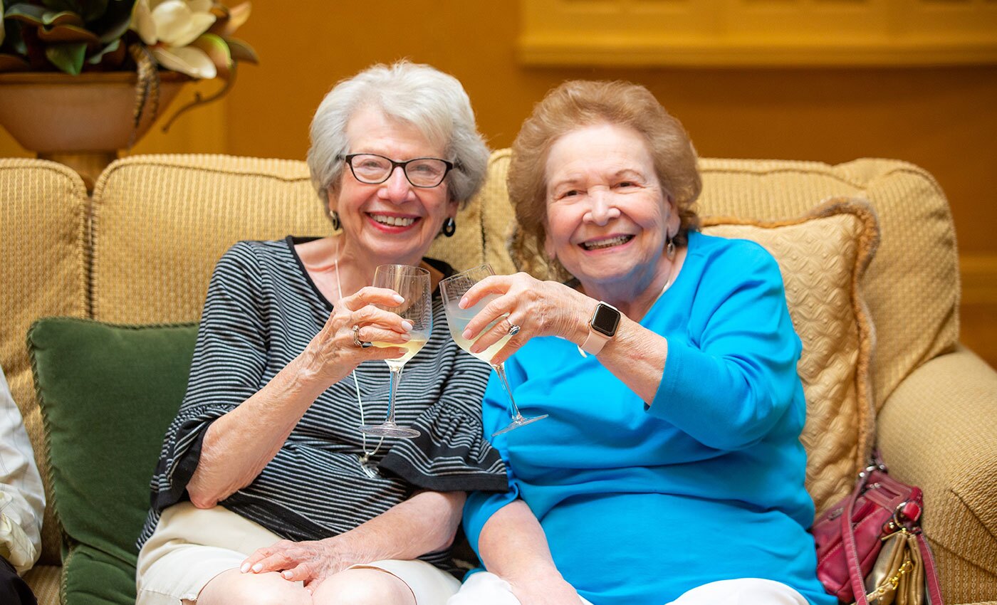 Two women toasting their glasses.