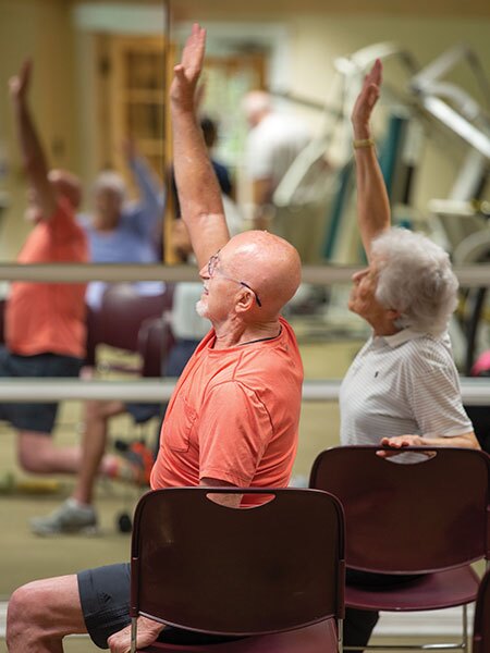Fitness class residents reaching up.