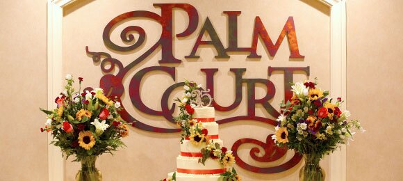Palm Court sign with flowers and cake.