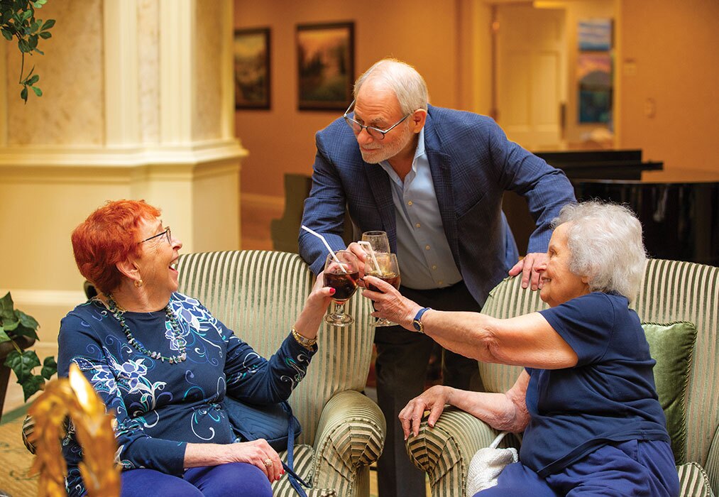 A group of three enjoying a cheers with their drinks.
