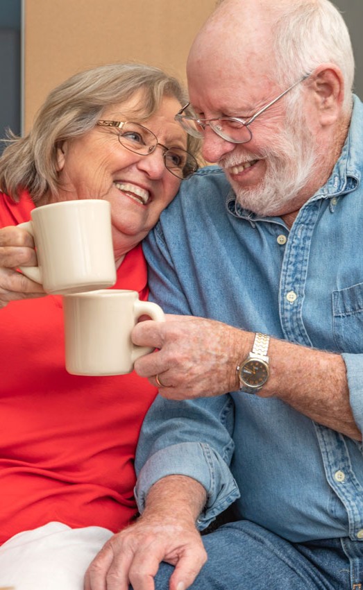 A couple enjoying coffee sitting on some steps.