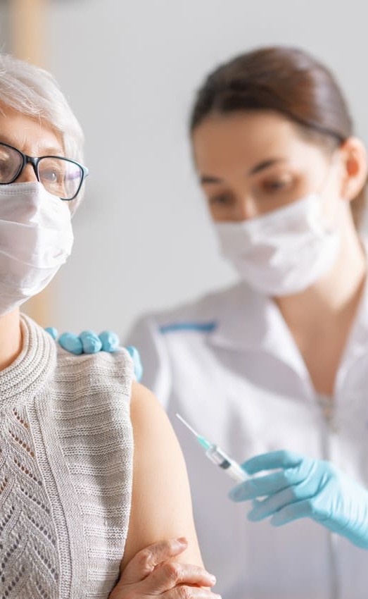 Female resident receives vaccine injection from doctor