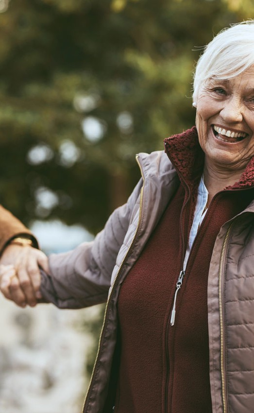 Man and woman holding hands outside and smiling