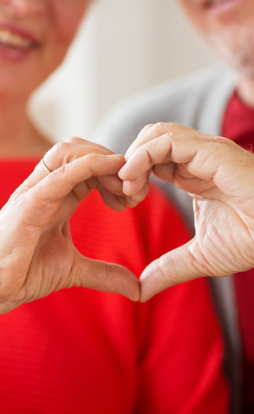 A couple making a heart shape with their hands to showcase heart health at The Gatesworth