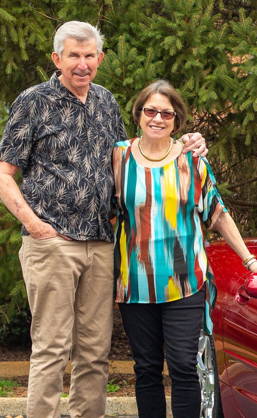 The Gatesworth residents standing outside next to red car