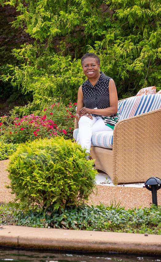 The Gatesworth resident sitting in a chair outdoors next to a pond.