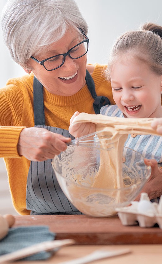 Grandmother and granddaughter baking in the kitchen.