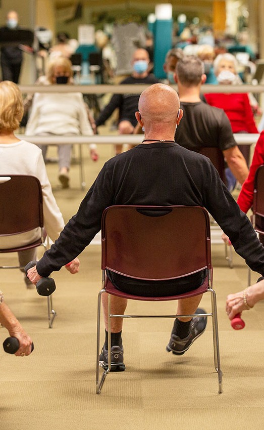 The Gatesworth residents lifting weights in a class in front of a mirror.