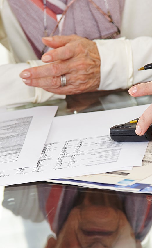 Closeup of three people discussing financial documents.