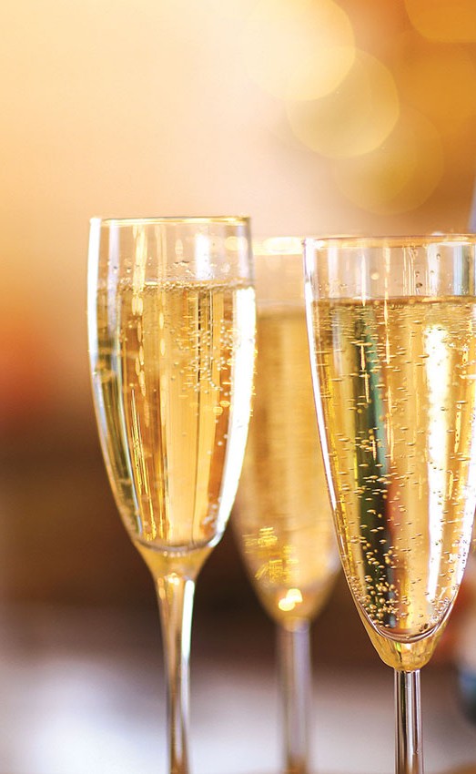 A close up of champagne glasses with lights in the background.