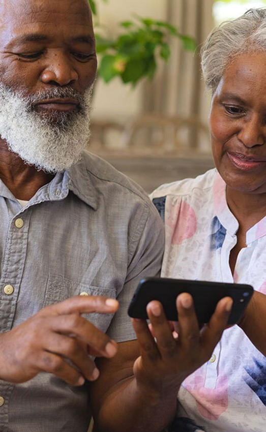 A couple looking at information on a mobile phone.