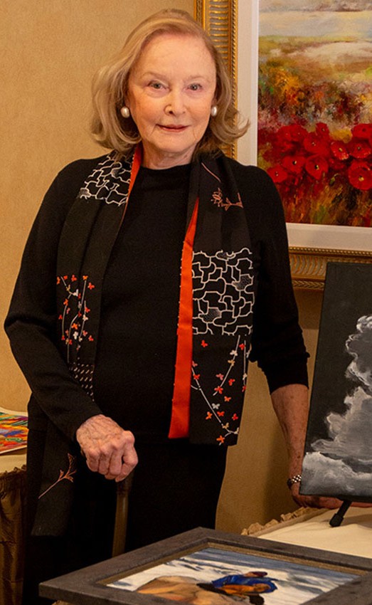 The Gatesworth resident standing next to a display of her paintings.