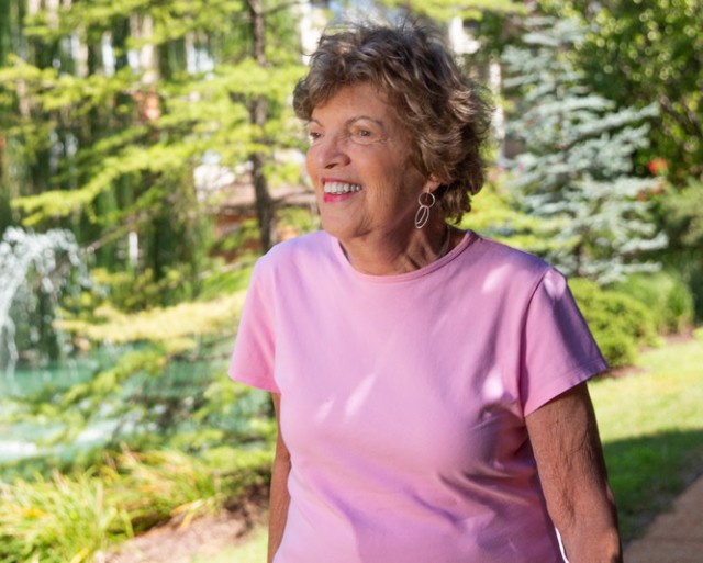 A resident walking outdoors smiling.