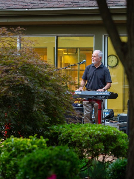 Man plays keyboard among the trees and bushes