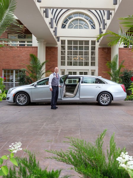 The Gatesworth chauffeur opening a car door