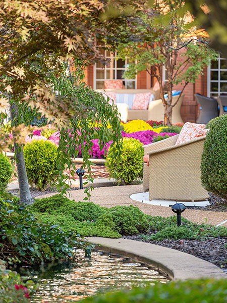 Outdoor seating area with plants and chairs.