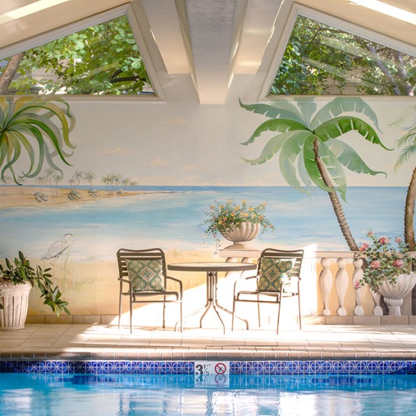 Empty chairs sitting next to an indoor pool.