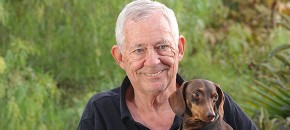 Resident holding a dog outdoors.