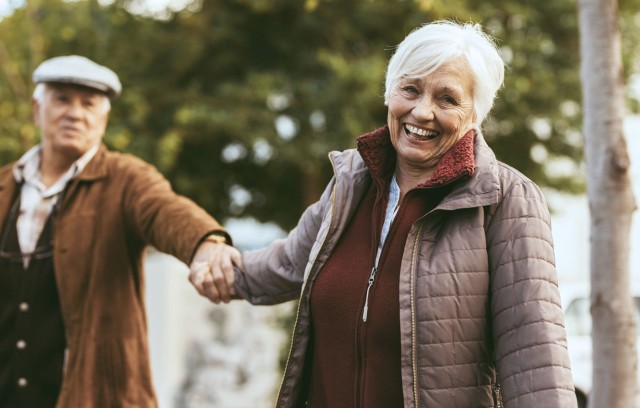 Man and woman holding hands outside and smiling