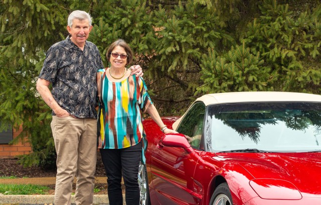 The Gatesworth residents standing outside next to red car