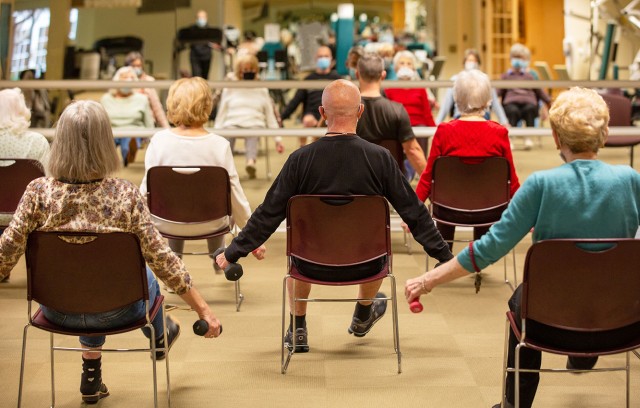 The Gatesworth residents lifting weights in a class in front of a mirror.