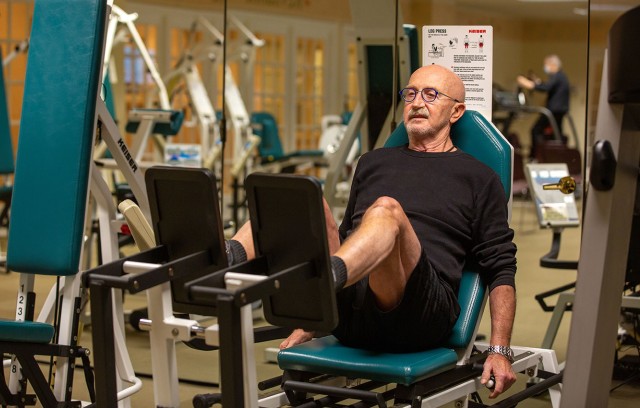 A resident exercising their legs in the gym.