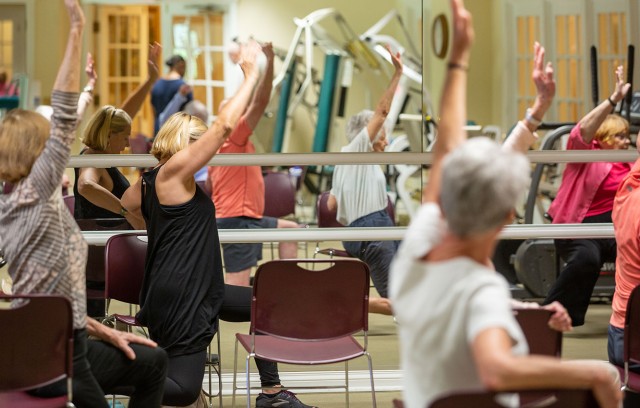 The Gatesworth exercise class with residents reaching in the air.