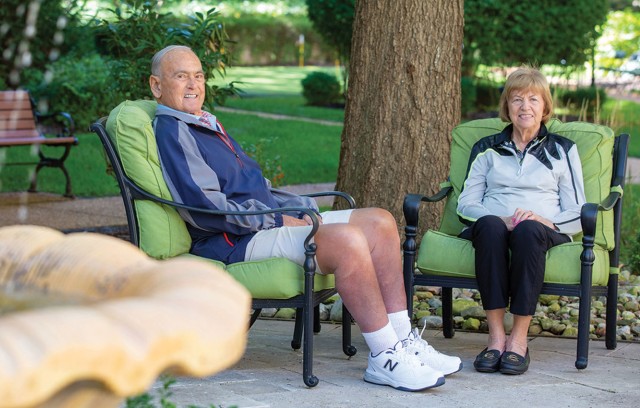 Residents sitting outside with a fountain in the foreground.