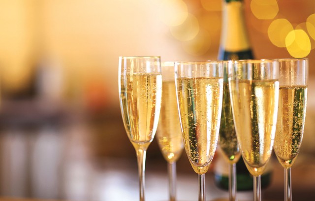 A close up of champagne glasses with lights in the background.