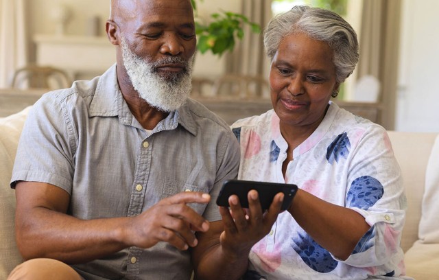 A couple looking at information on a mobile phone.