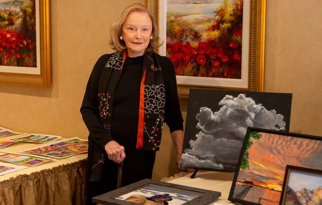 The Gatesworth resident standing next to a display of her paintings.