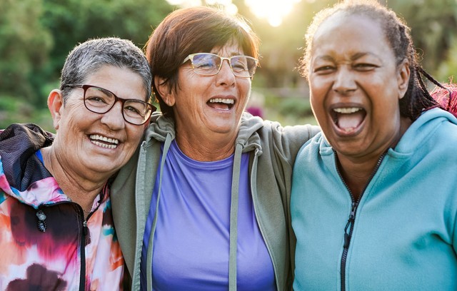 Three women smiling and laughing.