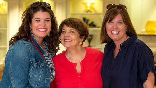 A mother smiling to the camera with her daughters.