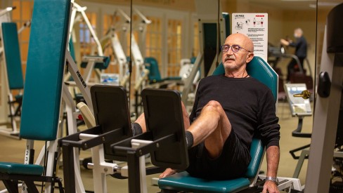 A resident exercising their legs in the gym.