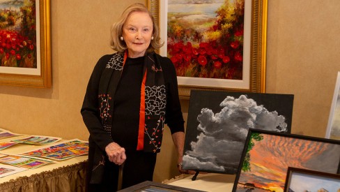 The Gatesworth resident standing next to a display of her paintings.