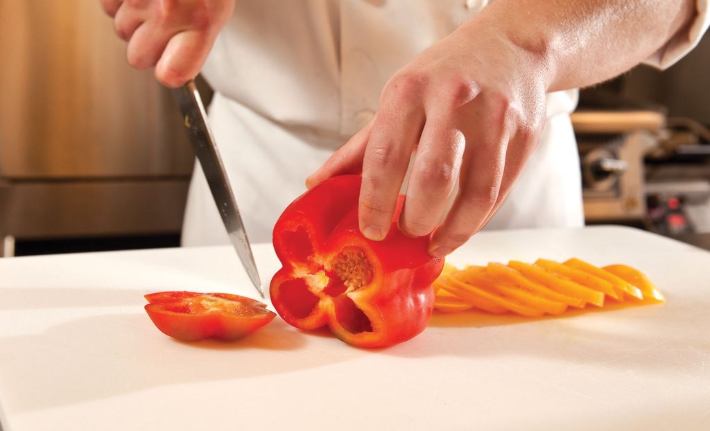 Chef chopping red bell pepper