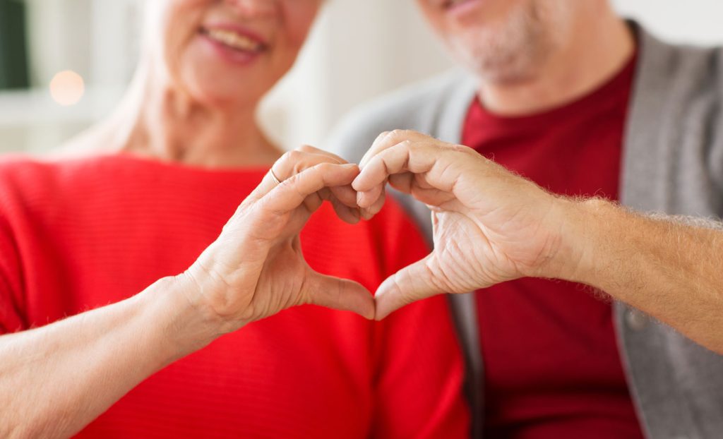 A couple making a heart shape with their hands to showcase heart health at The Gatesworth