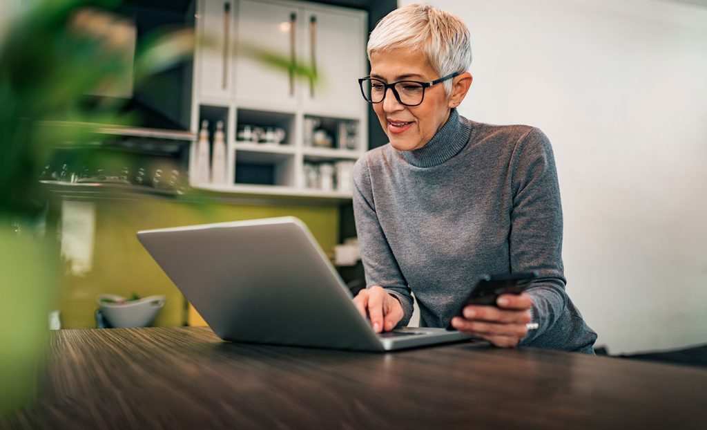 The Gatesworth woman in the kitchen on the computer.