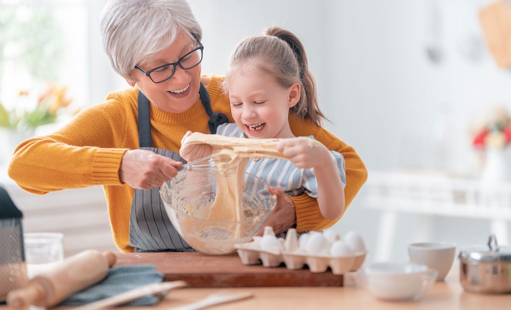 Grandmother and granddaughter baking in the kitchen.