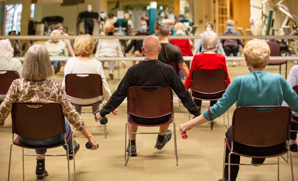 The Gatesworth residents lifting weights in a class in front of a mirror.