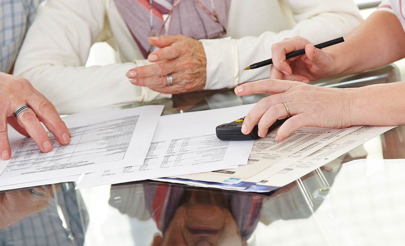 Closeup of three people discussing financial documents.