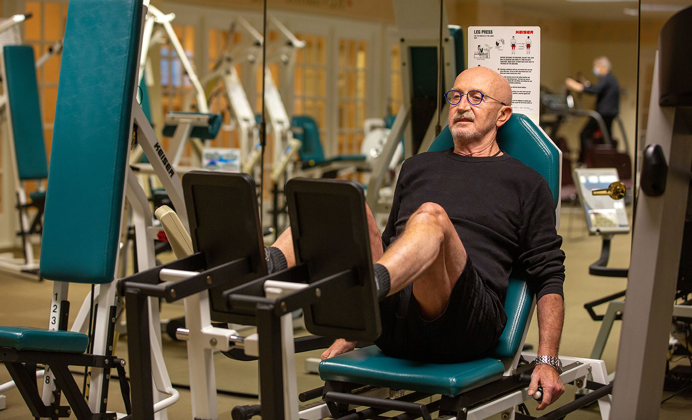 A resident exercising their legs in the gym.