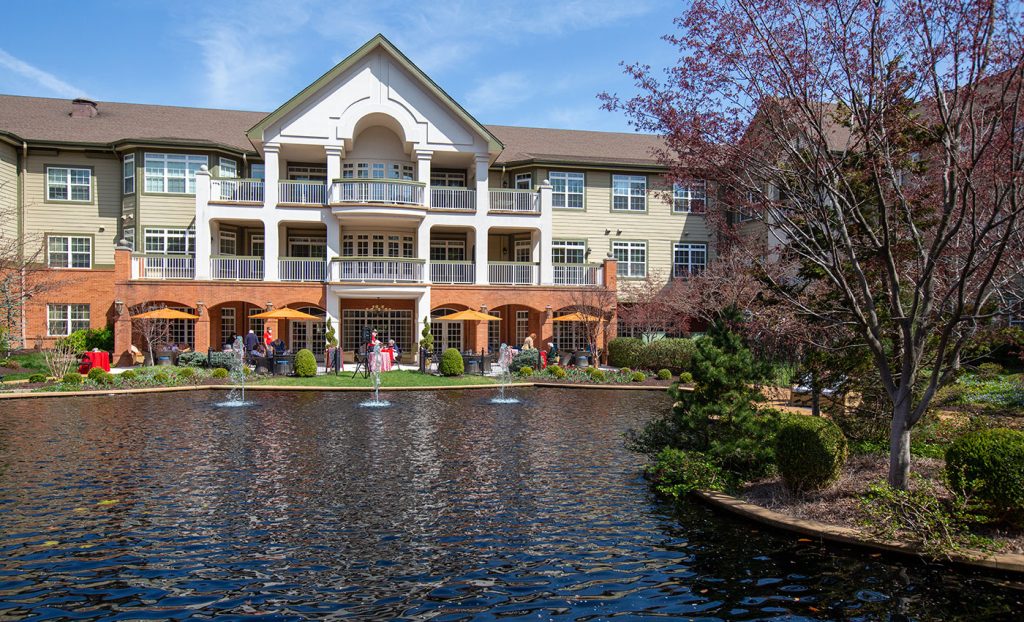 A sunny day looking at residents outdoors from across the pond.