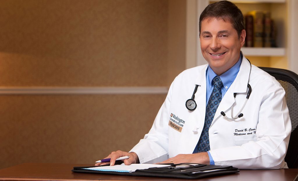Dr. Carr sitting at a desk.