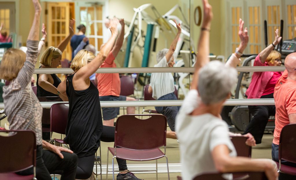 The Gatesworth exercise class with residents reaching in the air.