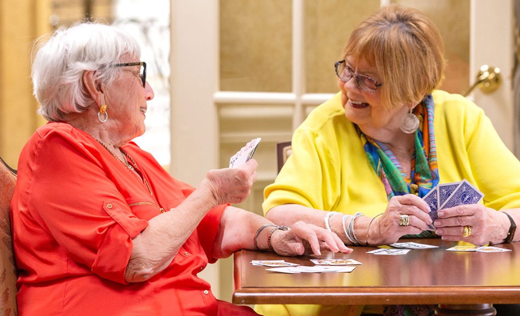 Two residents sitting at a table playing cards.
