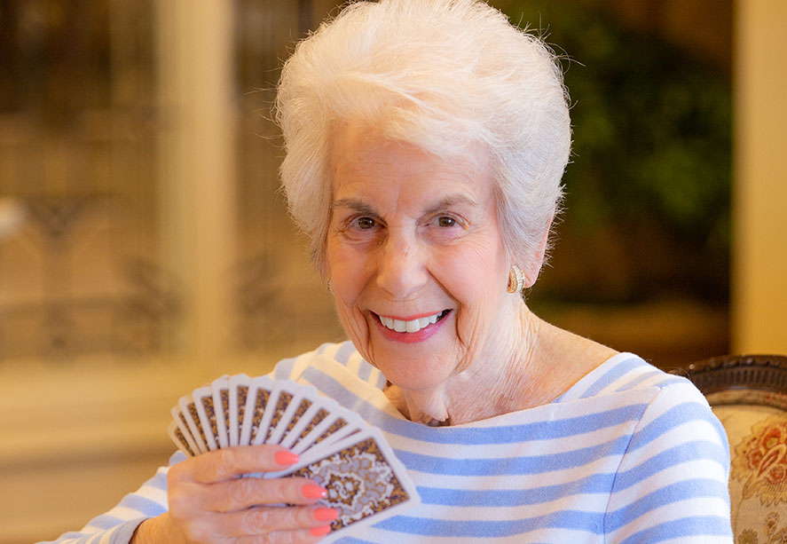 A woman holding a hand of playing cards.